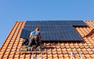 Ochojno, Poland - April 8, 2020: Workers installing solar electric panels on a house roof in  Ochojno. Poland