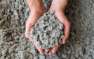 Close shot of eco friendly cellulose insulation filling held in hand 