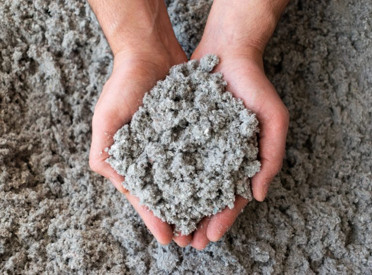Close shot of eco friendly cellulose insulation filling held in hand 